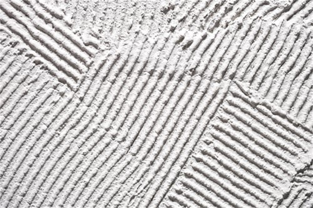 Close-up of applied drywall texture showing a combed trowel pattern on a residential wall