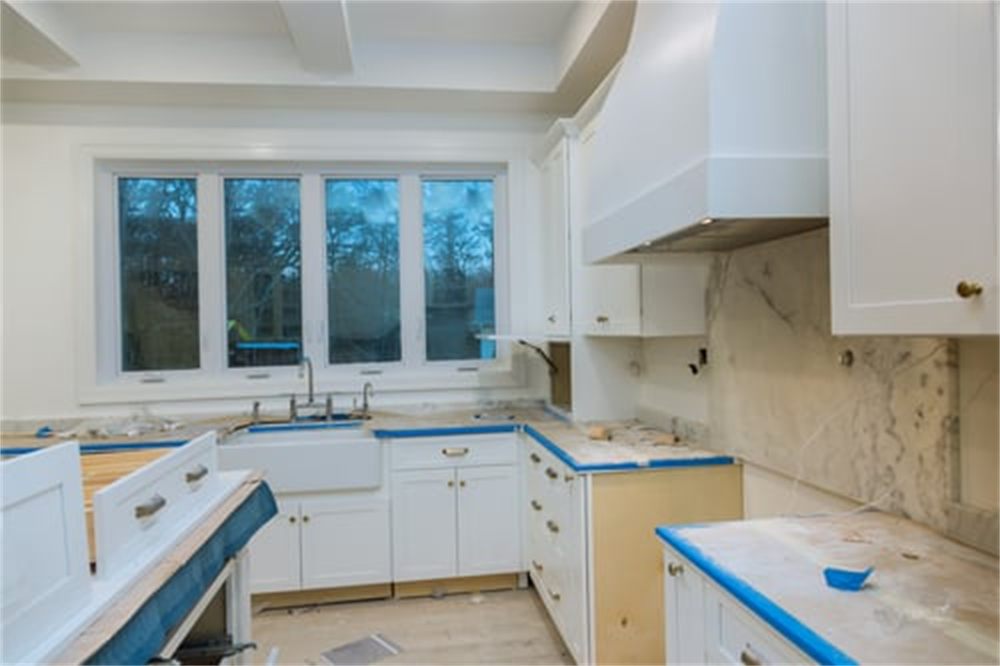 Bright white kitchen mid-remodel with marble backsplash and new cabinetry installed by Shark Constructions LLC in Denver, CO