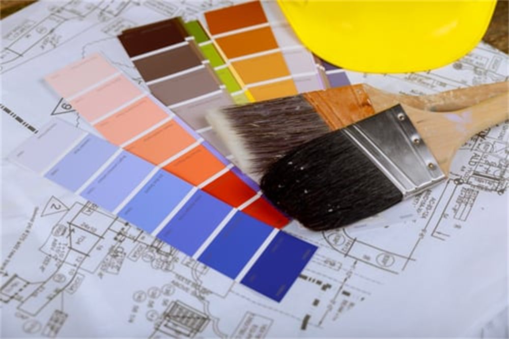 Paint color swatch fan, brushes and plans laid out for an interior and exterior painting project in Denver, CO