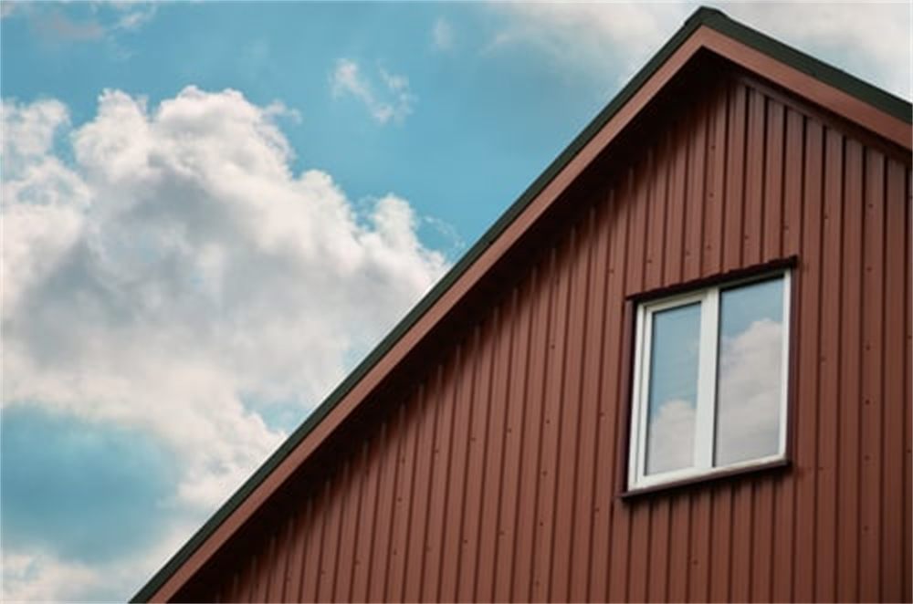 Vertical board-and-batten siding on a residential gable against a blue Colorado sky in the Denver metro area