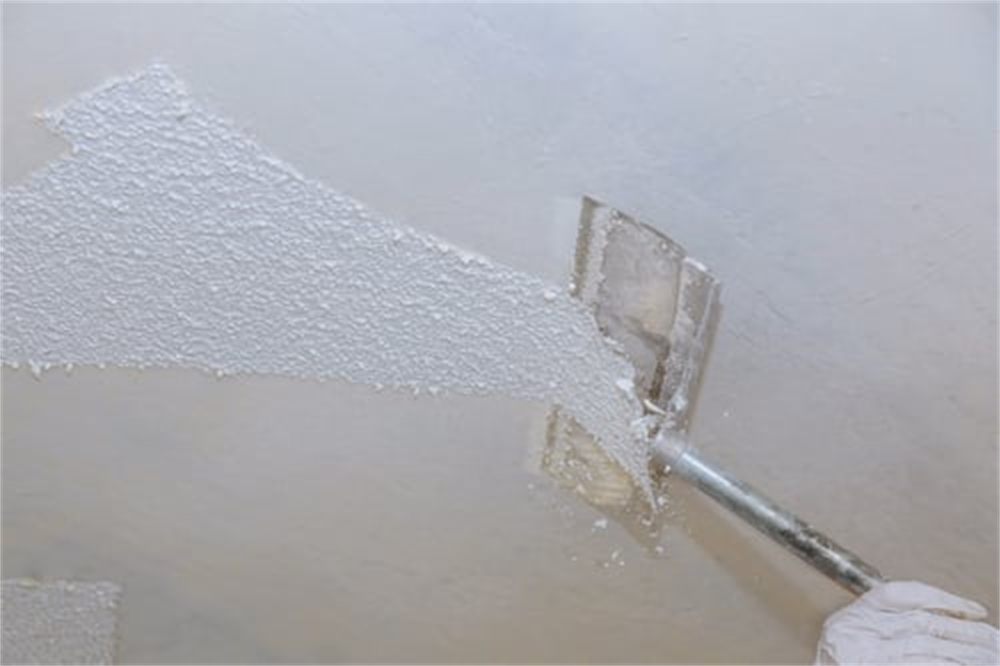 Drywall texture being applied and smoothed with a taping knife on a residential ceiling in Denver, CO